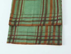 Detailed view of the plaid fabric texture and neat stitching on blazer hem and cuffs