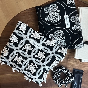 Detail view of cotton canvas pouches with butterfly embroidery and floral patterns