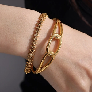 Polished gold-plated metal bangles with rivet design and chunky linked chain on wrist