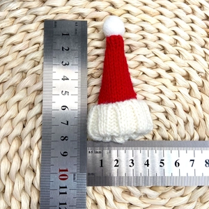 Détail d'un mini bonnet de Noël tricoté rouge et blanc avec mesure de 7,5 cm