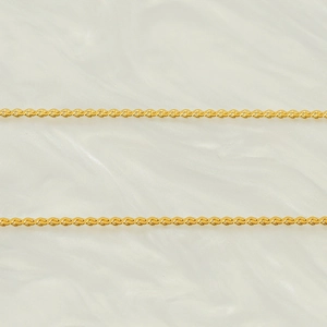 Close-up of golden stainless steel woven chain necklaces on white silk background