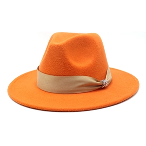 Detail eines orangen Wollfilzhutes mit Satinband und glitzernder Kristall-Schnalle