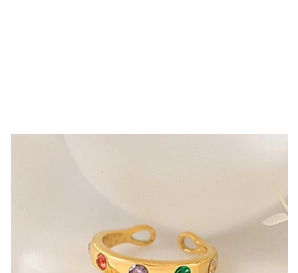 Détail d'une bague ouverte dorée ornée de zircons multicolores de style bohème