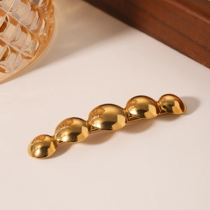 Minimalist gold stainless steel hair clip with five graduated hemispherical metal elements