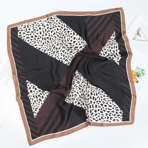 Détail d'un foulard en soie 70x70cm avec imprimé léopard et rayures géométriques