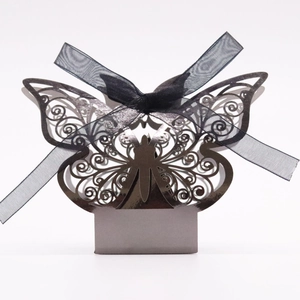 Macro shot of laser-cut silver butterfly gift box with elegant black chiffon ribbon