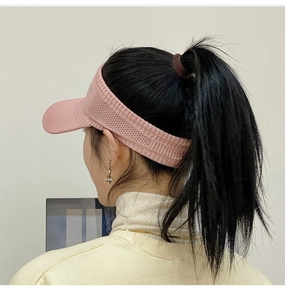 Detail view of pink knitted sun visor showing breathable mesh and elastic band