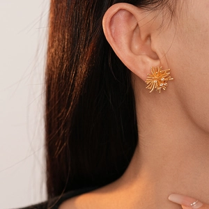 Gros plan de boucles d'oreilles étoiles dorées avec zircons sur un mannequin