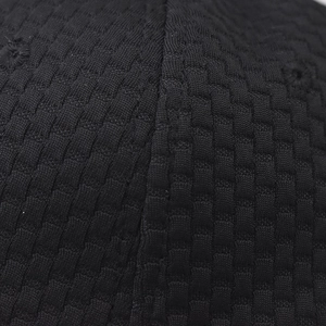 Macro shot of black baseball cap material featuring a square grid texture and stitching