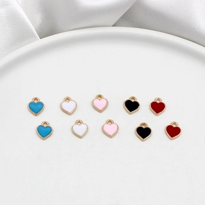 Detail of colorful heart enamel charms with gold frames for DIY jewelry crafts