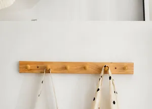 Detailansicht einer stilvollen weißen Canvas-Handtasche mit schwarzen Punkten am Holzhaken