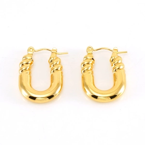 Détail macro de boucles d'oreilles dorées en U avec texture torsadée et poli brillant
