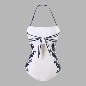Close-up of halter one-piece swimsuit featuring white fabric with blue wave patterns