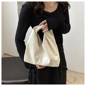 Minimalist white PU leather handbag for women held by model in elegant black dress