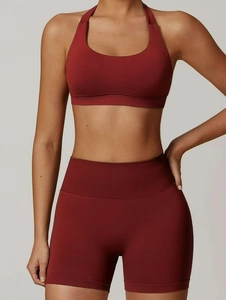 Detail of dark red seamless ribbed knit high-waist yoga set and halter neck sports bra