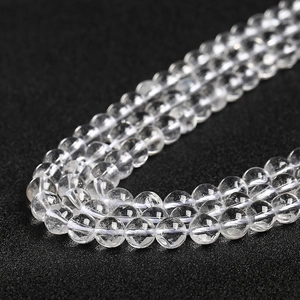 Polished natural transparent crystal beads on a textured black background for DIY jewelry