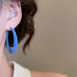 Détail d'une créole bleue floquée montrant la texture velours mat sur un mannequin