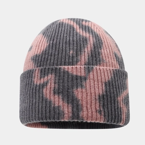 Detailed view of the thick vertical rib knit texture and pink tie-dye pattern on the beanie