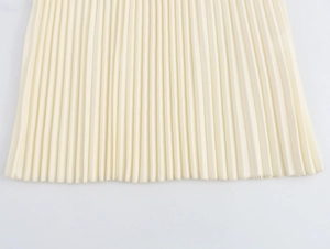 Close-up of beige pleated fabric hem with detailed stitching and fine texture