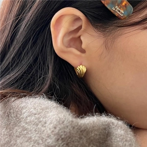 Elegant 925 sterling silver shell earrings in gold finish worn on a model's ear