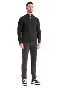 Detail of dark green waffle knit cardigan with ribbed cuffs and classic button closure