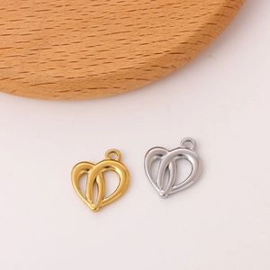 Detail of heart-shaped hollow charms in gold and silver finish for DIY jewelry