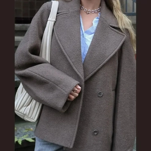 Detailed texture of coffee wool coat featuring double-breasted design and lapel collar