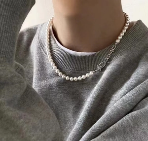 Detail eines silbernen U-Verschlusses, der eine Perlenkette an einem Modell verbindet