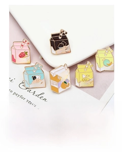 Detail of six enamel milk carton lapel pins in assorted flavors with colorful designs