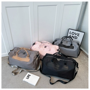 Group view of large waterproof travel bags in black, pink, grey, and khaki on a soft rug