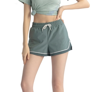 Women's sage green high-waisted sports shorts with white trim and mesh side panels