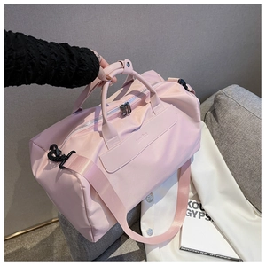 Pink waterproof fitness bag with top handles and adjustable shoulder strap on a sofa