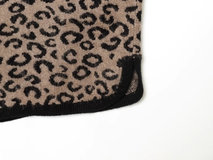 Detailed macro shot of leopard print knit fabric with ribbed edges and side slit design