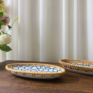 Detail of blue and white ceramic plate with handwoven rattan edge on wooden table