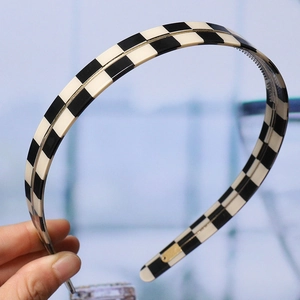 Close-up of classic black and white checkered headband for women daily hair styling