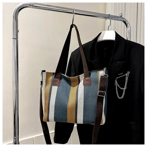 Vertical striped canvas tote bag detail featuring adjustable shoulder strap on hanger