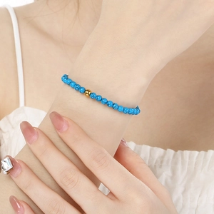 Bracelet en perles de pierre naturelle bleu ciel avec perle dorée porté au poignet