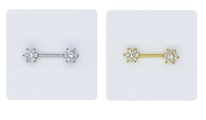Detailed macro view of gold and silver flower nipple rings with sparkling cubic zirconia