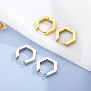 Vue détaillée de créoles hexagonales géométriques en finitions or et argent poli