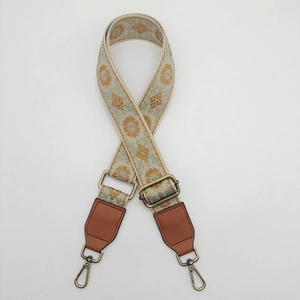 Detail of bohemian floral canvas strap with bronze metal buckles and leather ends