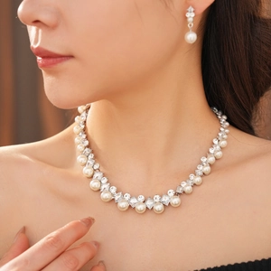 Detail view of model wearing elegant pearl and zircon necklace set with matching earrings