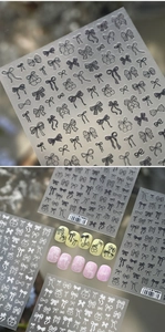 Detail von schwarz-weißen Schleifen-Nagelstickern mit verschiedenen feinen Designs
