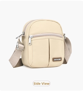 Detailed side view of cream nylon crossbody bag featuring adjustable wide strap and zippers