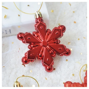 Macro shot of a red metallic snowflake Christmas ornament with gold hanging string