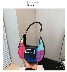 Detail of color-block crescent bag featuring geometric patterns and golden metal trim
