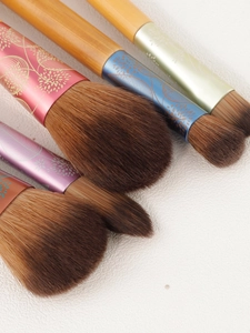 Detailed macro view of makeup brushes with floral metal ferrules and wood handles