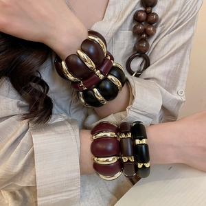 Detail of vintage acrylic cuff bracelet in burgundy and black with gold accents
