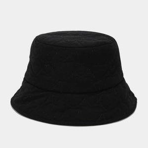 Detail of black corduroy bucket hat featuring heart-shaped quilted pattern and texture