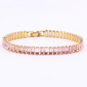 Detail of pink rectangular zircons set in a gold plated tennis bracelet with fold-over clasp