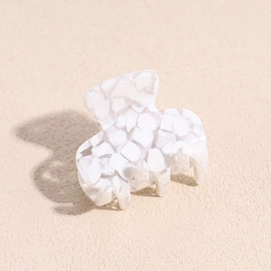 Detail of elegant marble texture acetate hair claw clip on neutral background